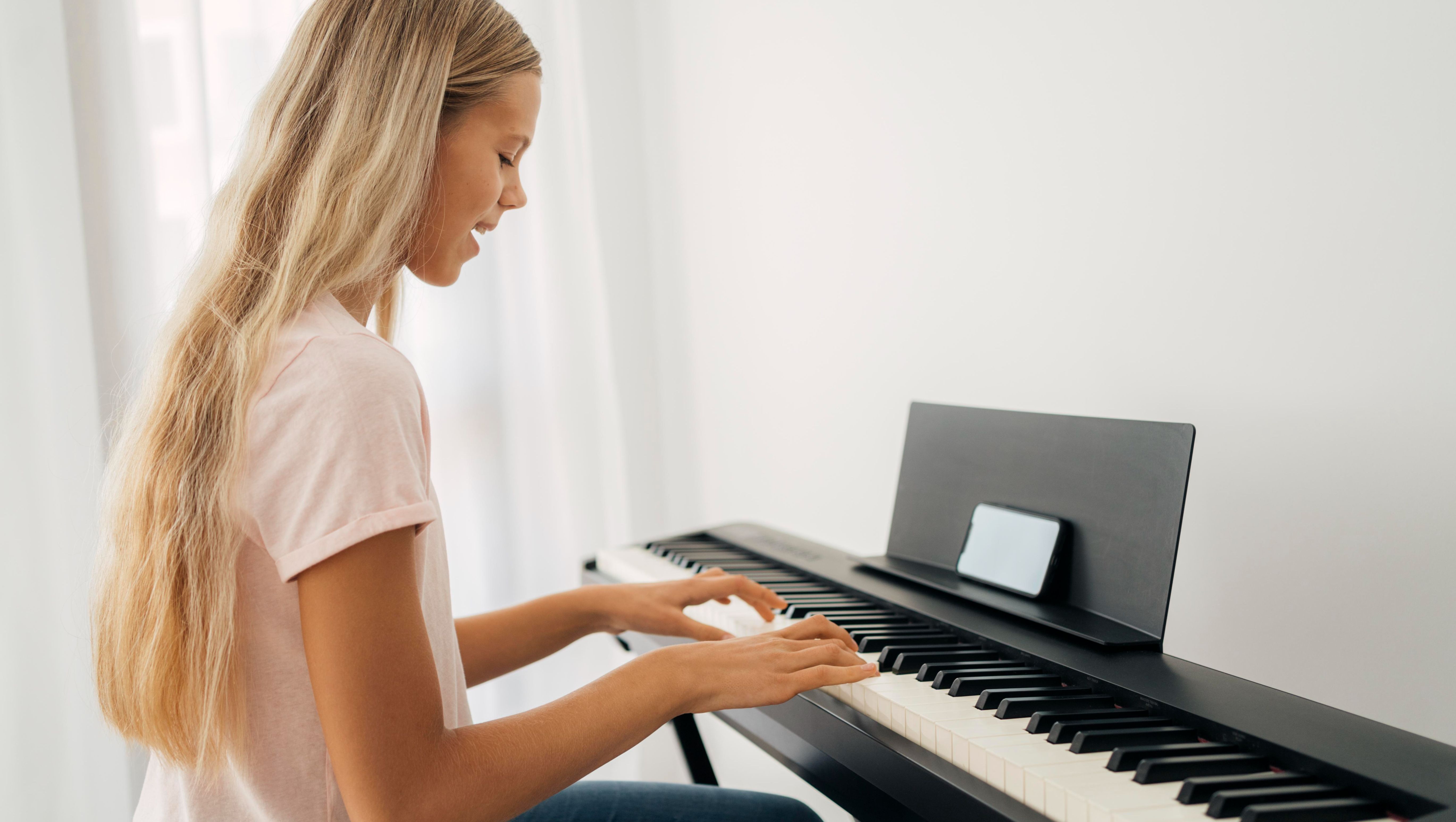 blond flicka spelar självspelande piano